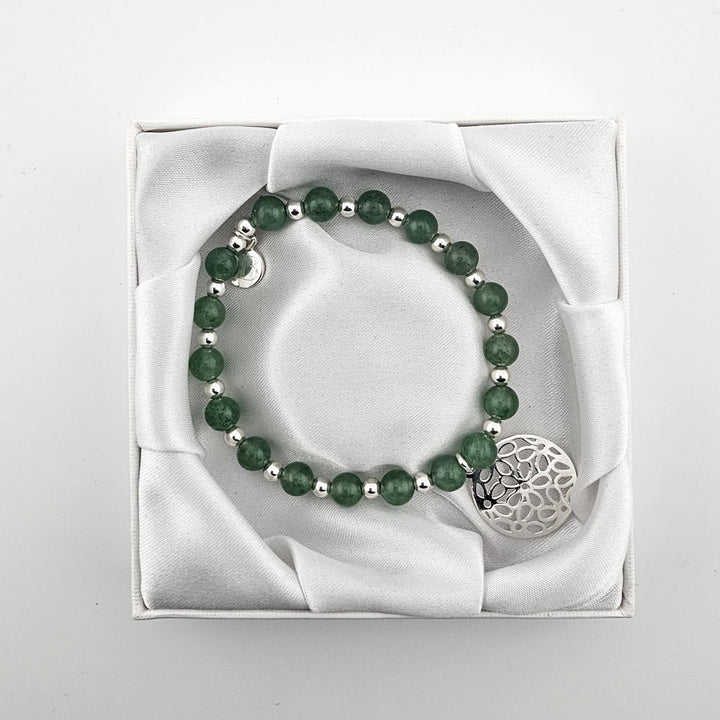 Top view of green aventurine gemstone bracelet with filigree charm in satin box.