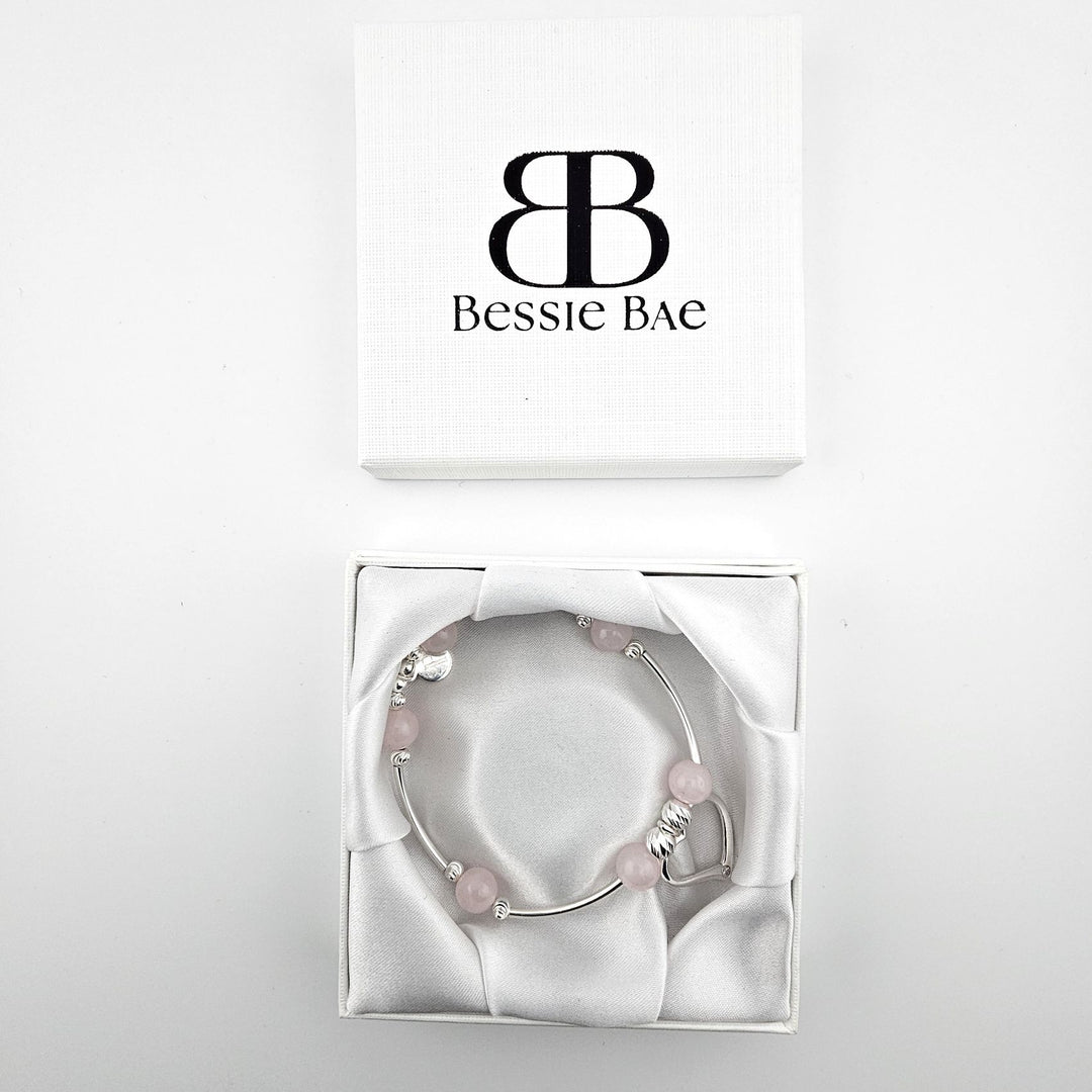 Sterling silver heart charm bracelet with rose quartz presented in Bessie Bae gift box.