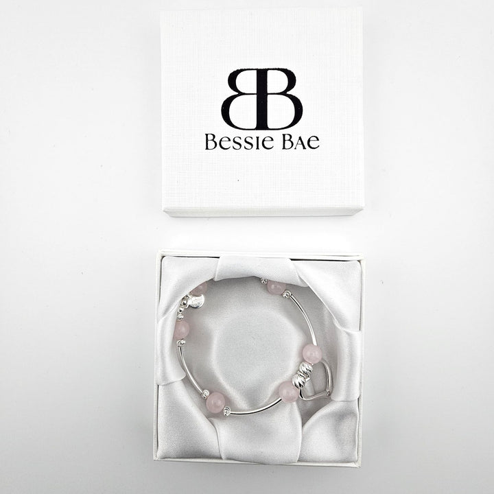 Sterling silver heart charm bracelet with rose quartz presented in Bessie Bae gift box.