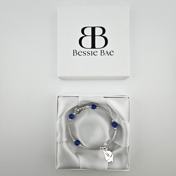Sterling silver sailboat bracelet with blue beads presented in Bessie Bae gift box.