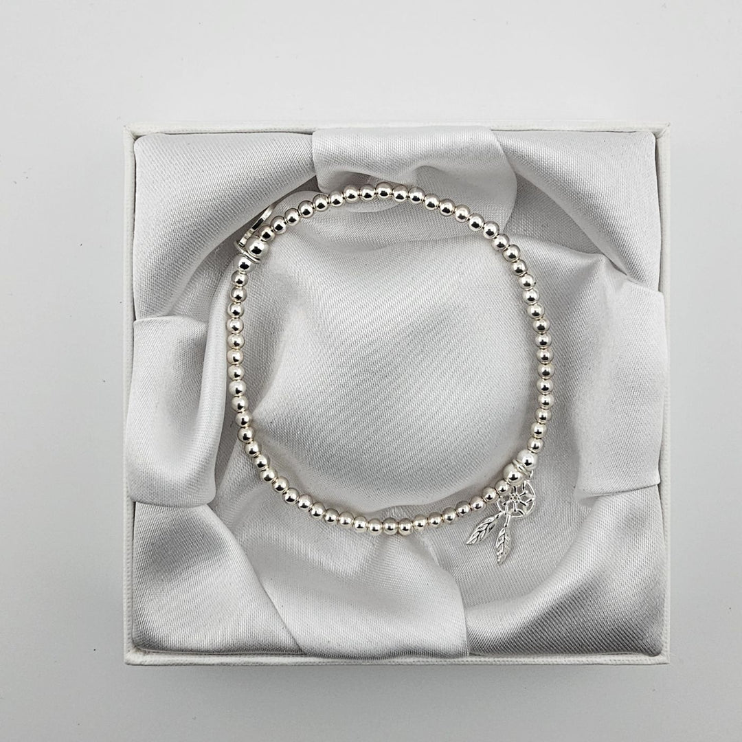 Top view of sterling silver beaded bracelet with dreamcatcher charm in box.