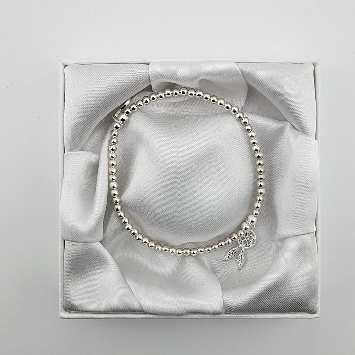 Top view of sterling silver beaded bracelet with dreamcatcher charm in box.