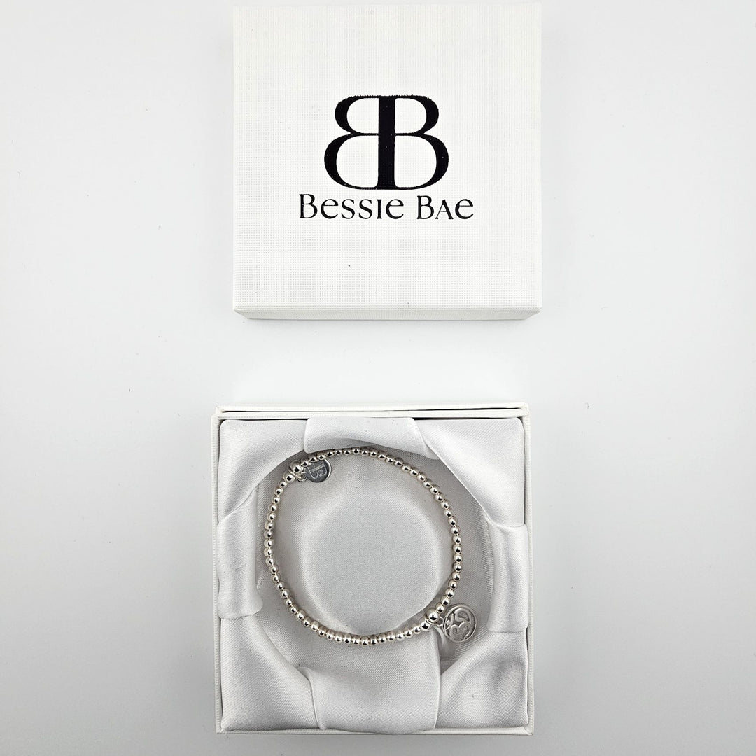 Silver Om charm bracelet displayed in Bessie Bae gift box.
