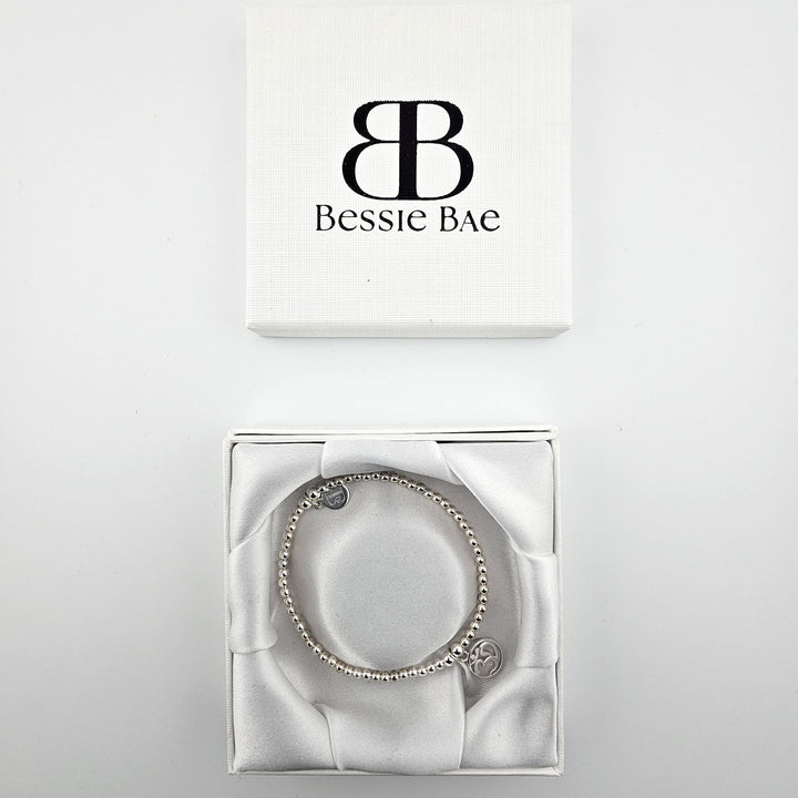 Silver Om charm bracelet displayed in Bessie Bae gift box.