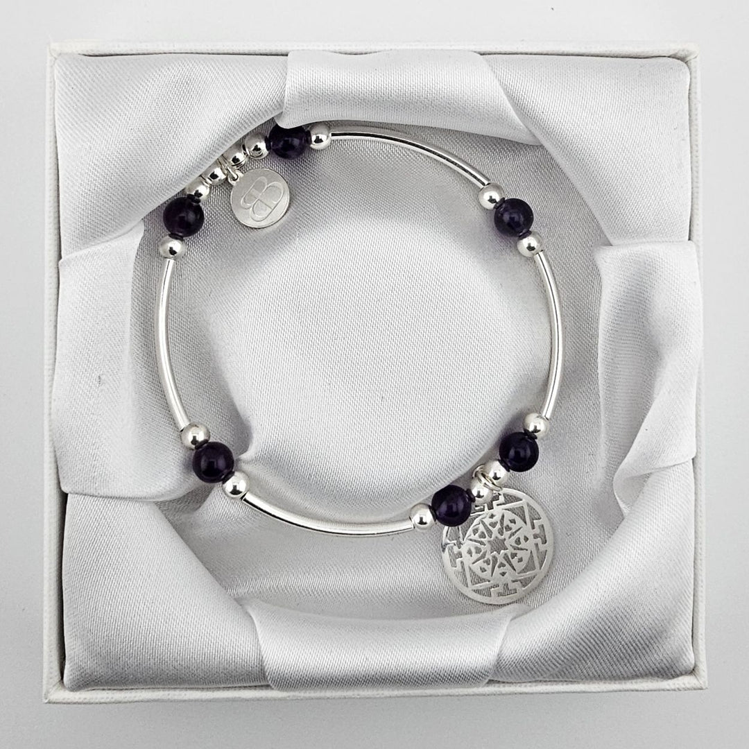 Amethyst gemstone bracelet with silver mandala pendant.