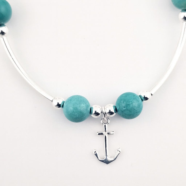 Silver and turquoise beaded bracelet with anchor charm.
