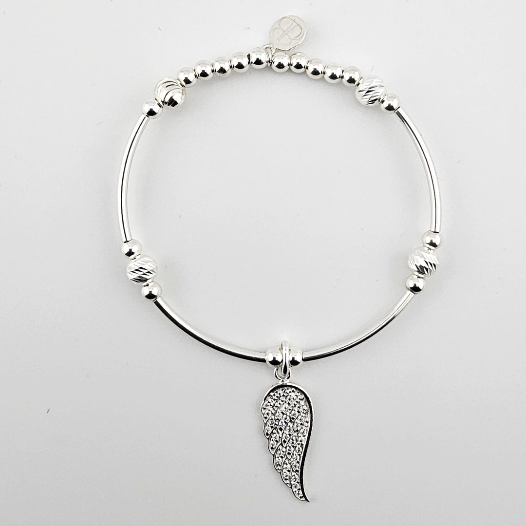 Sterling silver bracelet with sparkling angel wing charm on white background.