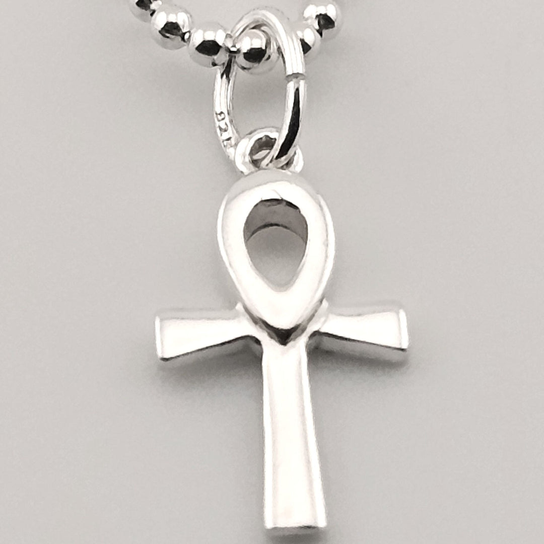 Close-up of sterling silver ankh pendant with polished finish on chain.