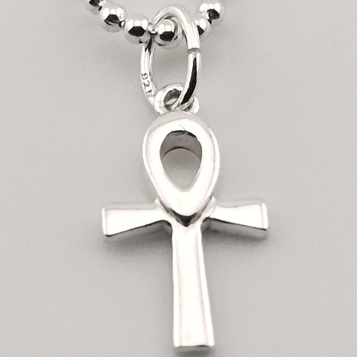 Close-up of sterling silver ankh pendant with polished finish on chain.