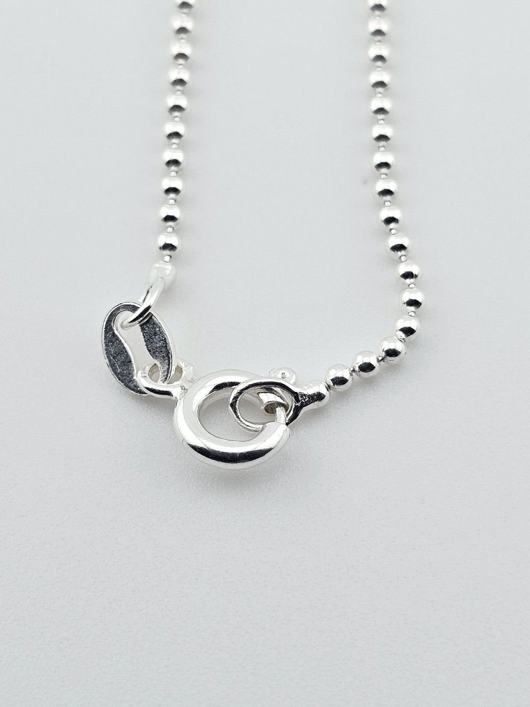 Detail view of 925 sterling silver necklace clasp and bead chain design.