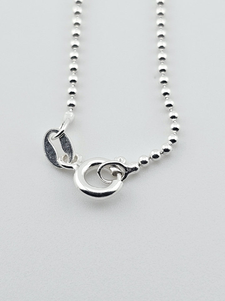 Detail view of 925 sterling silver necklace clasp and bead chain design.
