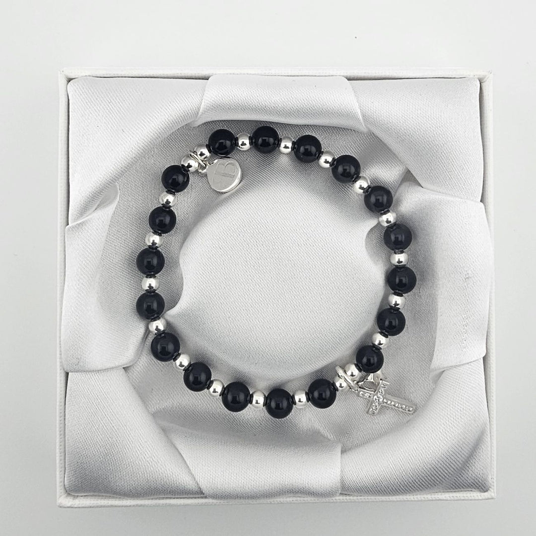 Handmade sterling silver and black onyx bracelet with cross charm.