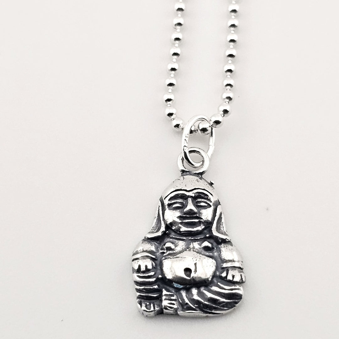 Close-up of sterling silver Buddha necklace, symbolic peace and fortune pendant.