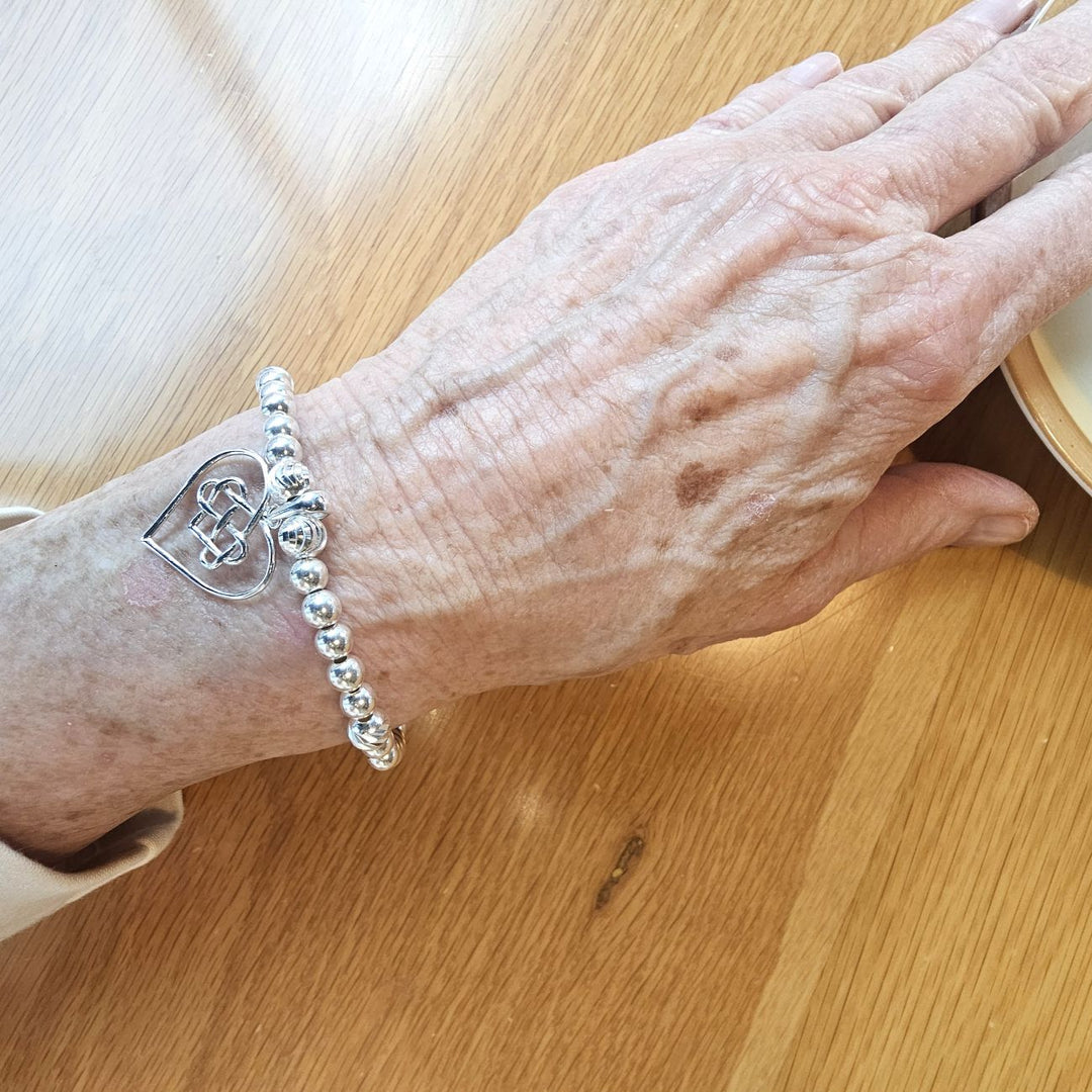 Sterling Silver Celtic Heart Bracelet by Bessie Bae, shown on wrist with beaded design and intricate Celtic heart charm.