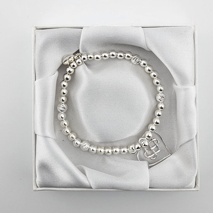 Top view of Celtic heart silver bracelet in satin box.
