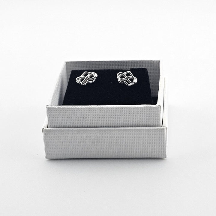 Dainty silver heart earrings with scroll fittings.