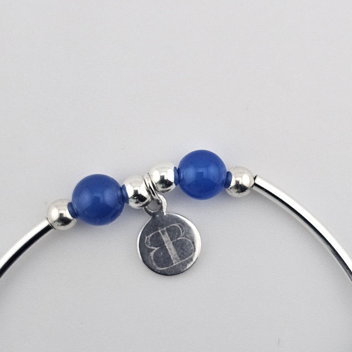Blue gemstone bracelet with sterling silver compass charm.