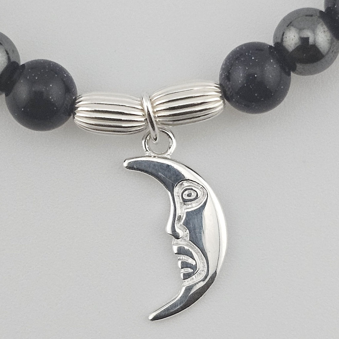 Close-up of Sterling Silver crescent moon charm on Blue Goldstone bracelet.