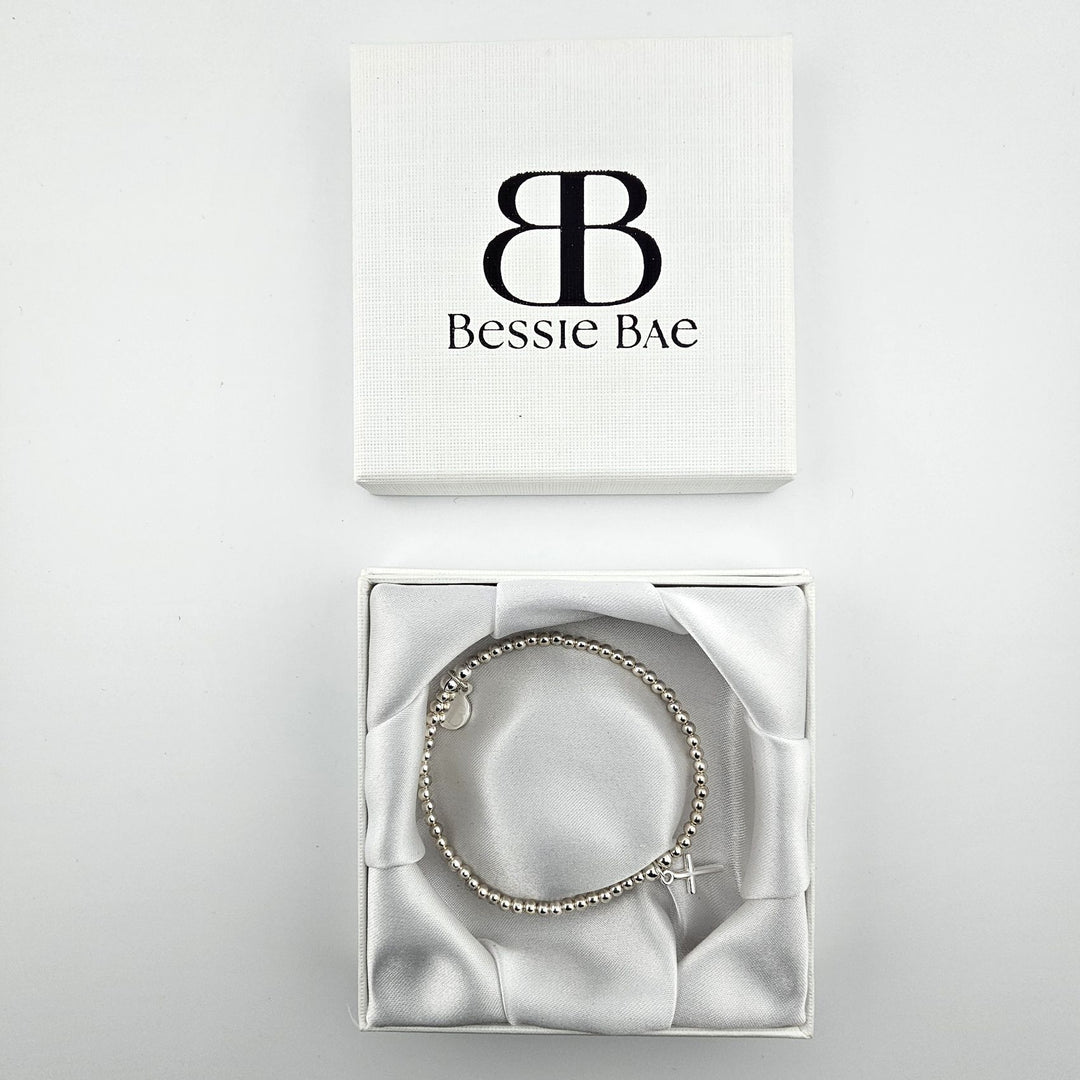 Sterling silver cross charm bracelet presented in Bessie Bae gift box.