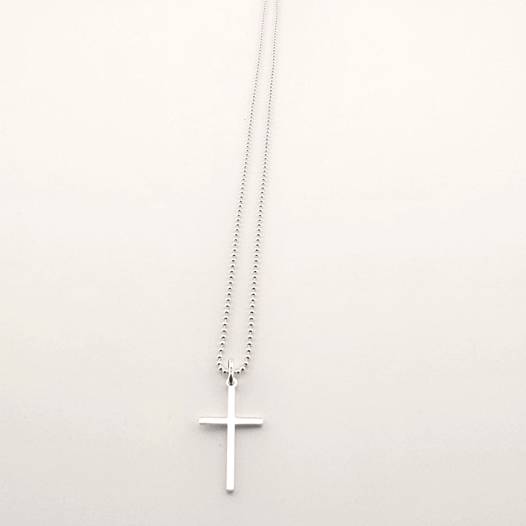 Sterling silver cross pendant necklace with fine chain, minimalist design.