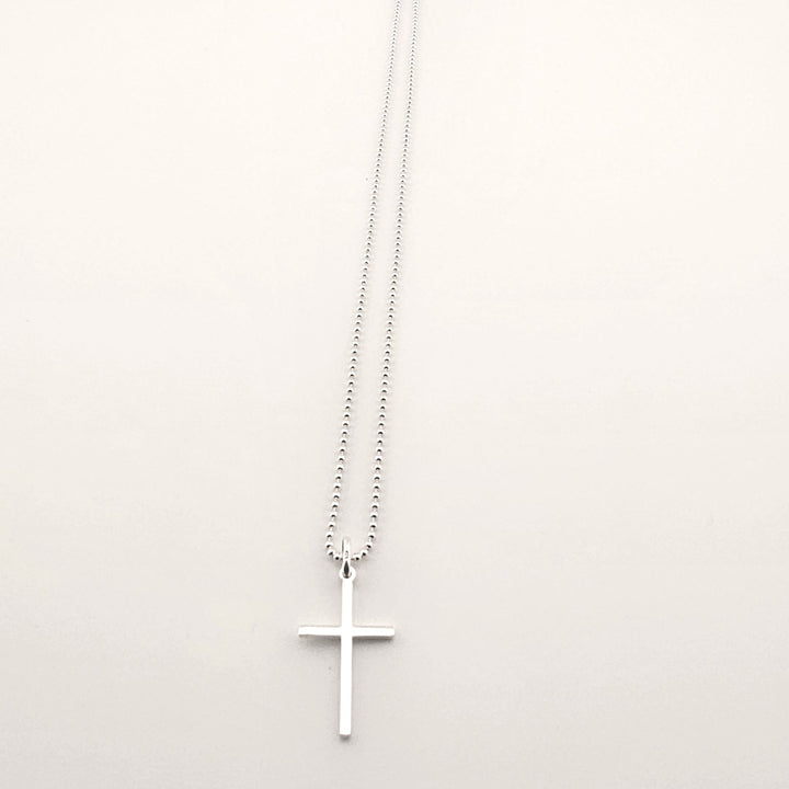 Sterling silver cross pendant necklace with fine chain, minimalist design.
