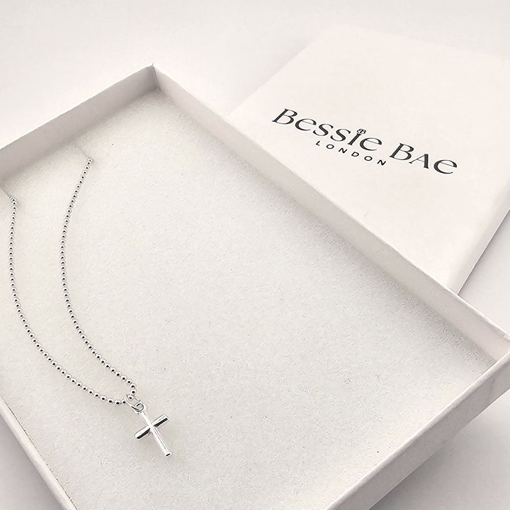 Sterling silver cross necklace with polished pendant on fine chain in box