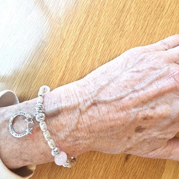 Sterling Silver Dream Explore Discover Bracelet with Rose Quartz and Star Charm by Bessie Bae, shown on wrist with textured silver beads and pink gemstone accents.