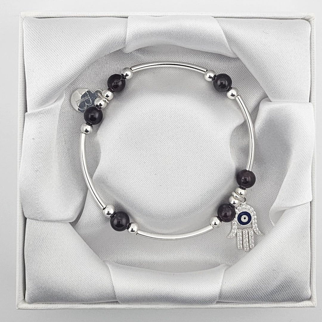 Garnet gemstone bracelet featuring Hamsa Hand and evil eye design.