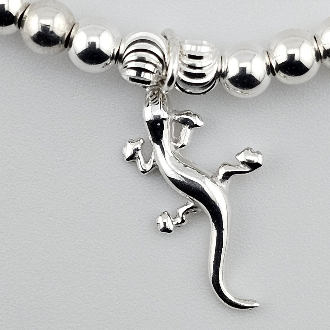 Close-up of sterling silver gecko charm showing detailed design.