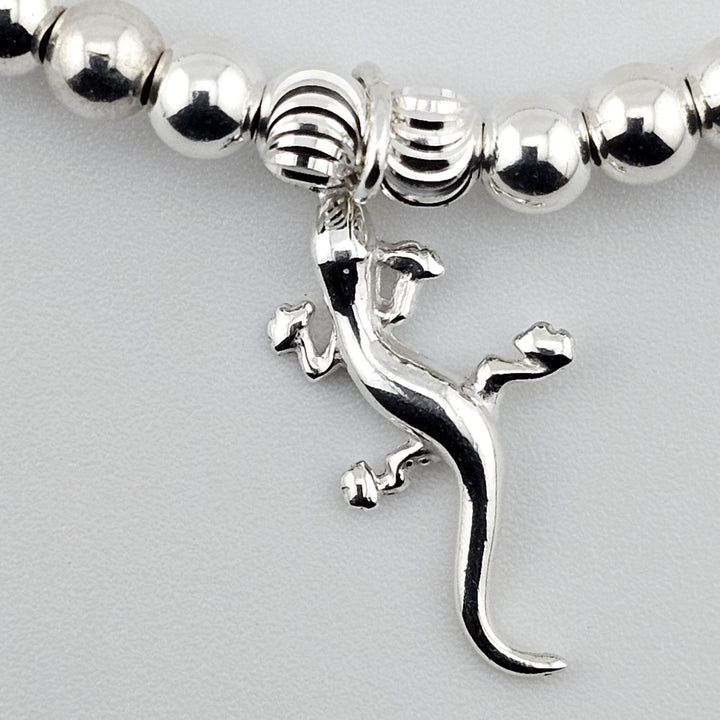 Close-up of sterling silver gecko charm showing detailed design.