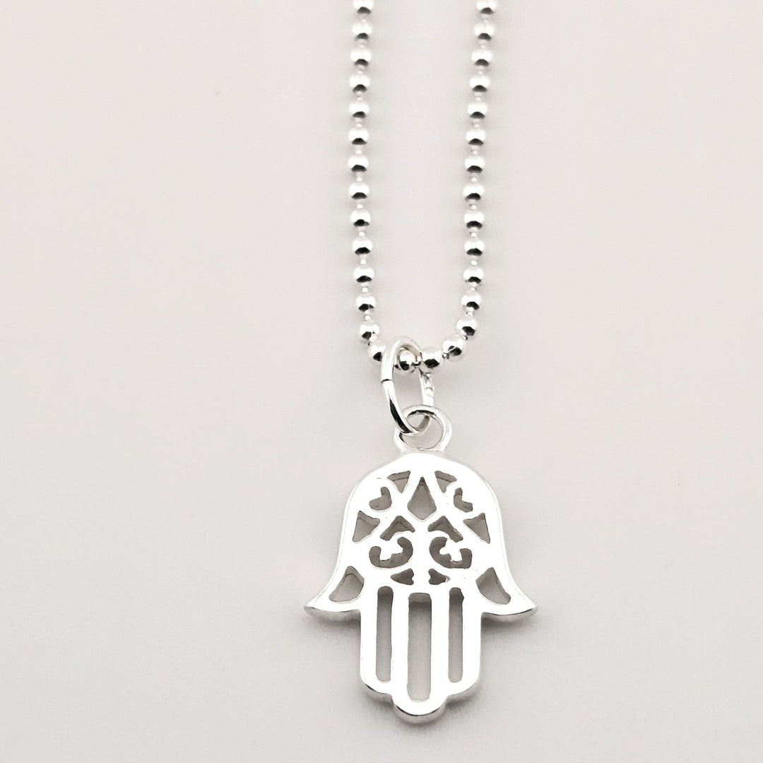 Close-up of sterling silver Hamsa necklace with cut-out pendant design.