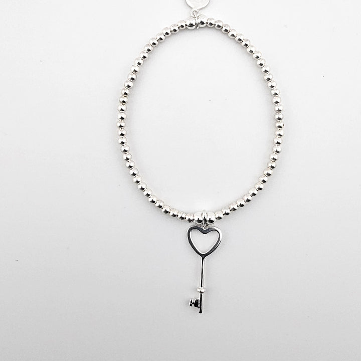 Sterling silver bracelet with heart key charm.