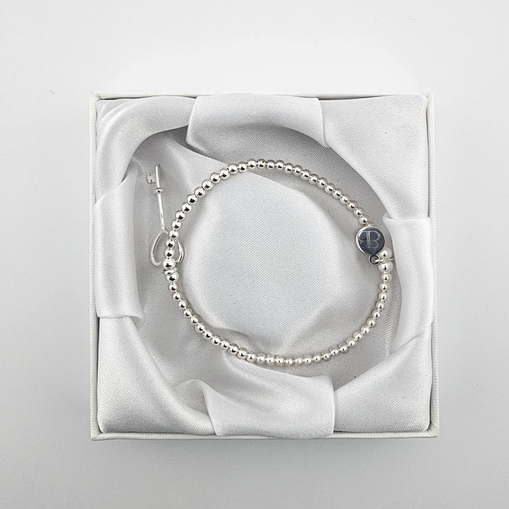 Minimalist silver bracelet with key charm for women.
