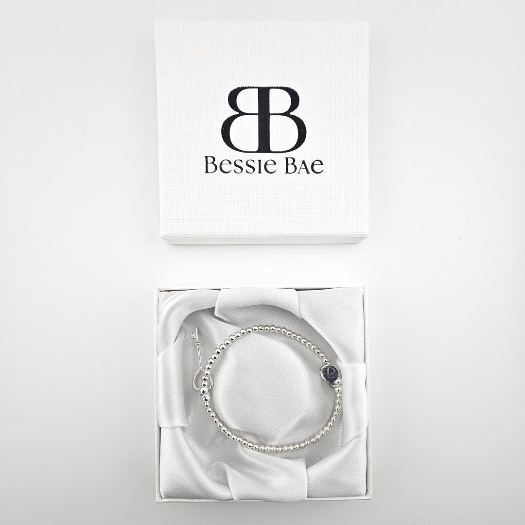 Delicate beaded bracelet featuring silver heart key pendant.