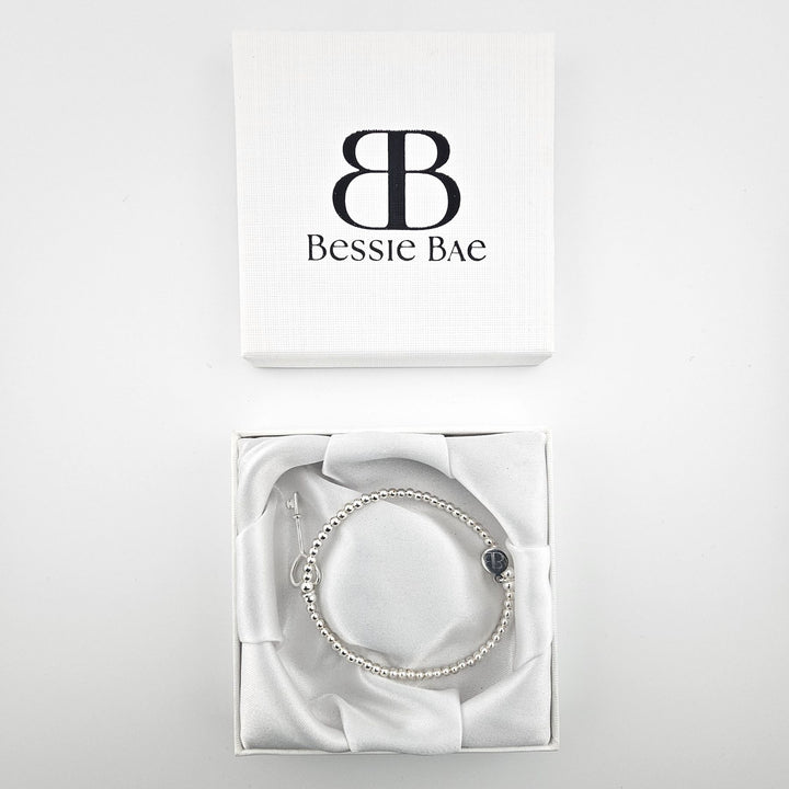 Delicate beaded bracelet featuring silver heart key pendant.