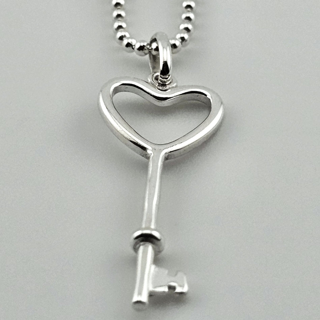 Elegant sterling silver heart key necklace on fine chain.