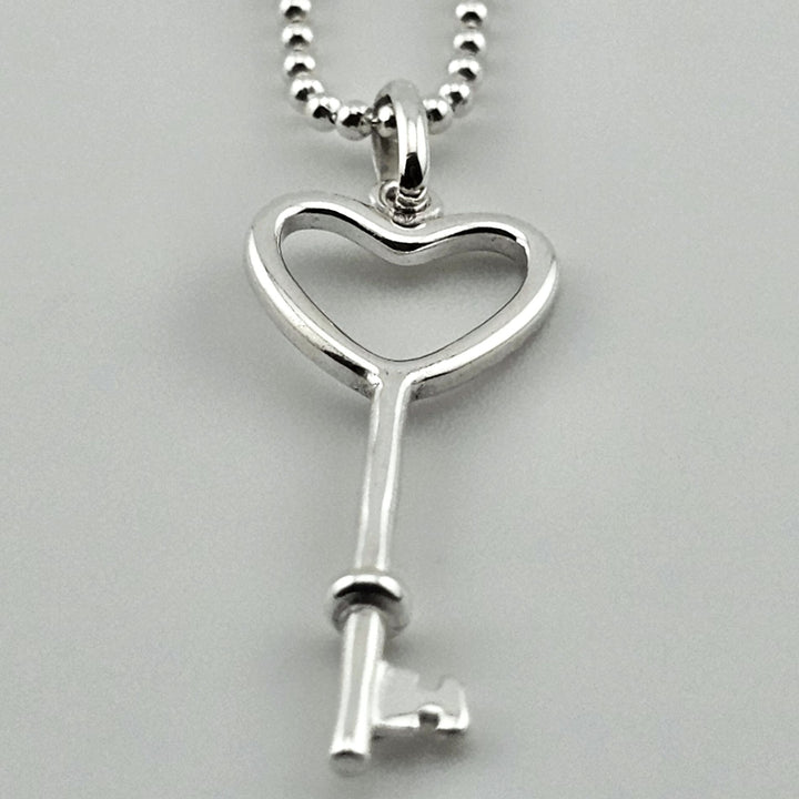Elegant sterling silver heart key necklace on fine chain.