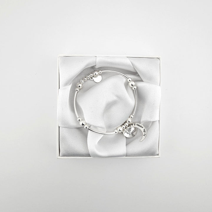 Silver curved tube bracelet featuring engraved moon charm.
