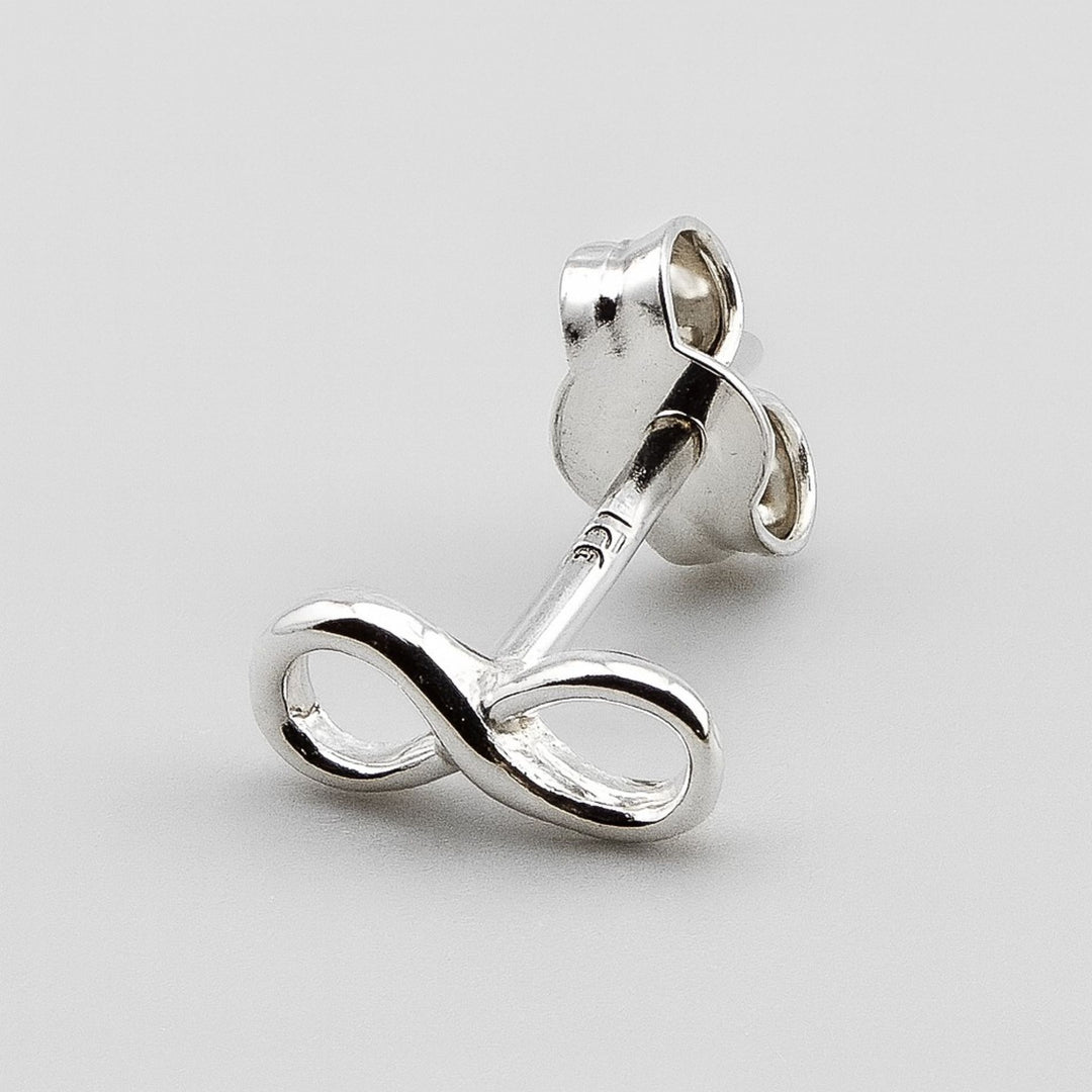 Minimalist silver infinity earrings with scroll fittings.