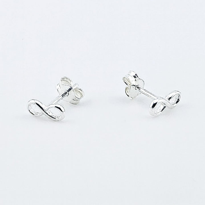 Sterling silver infinity stud earrings with butterfly backs.