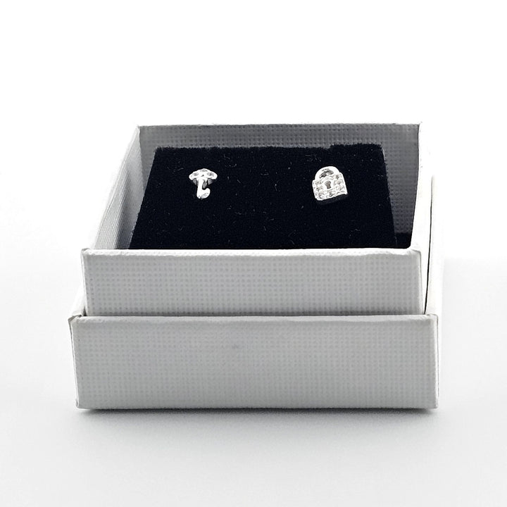 Mismatched sterling silver padlock and key stud earrings.