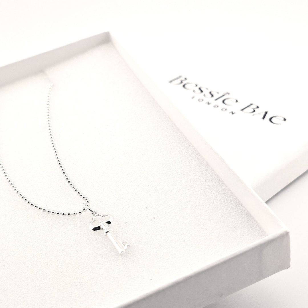 Sterling silver key pendant necklace on fine chain, vintage-style design.