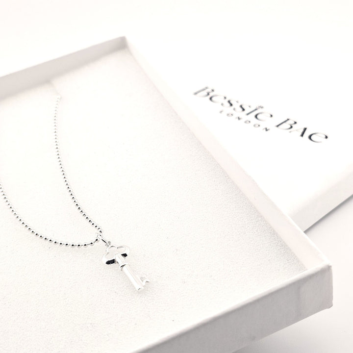 Sterling silver key pendant necklace on fine chain, vintage-style design.