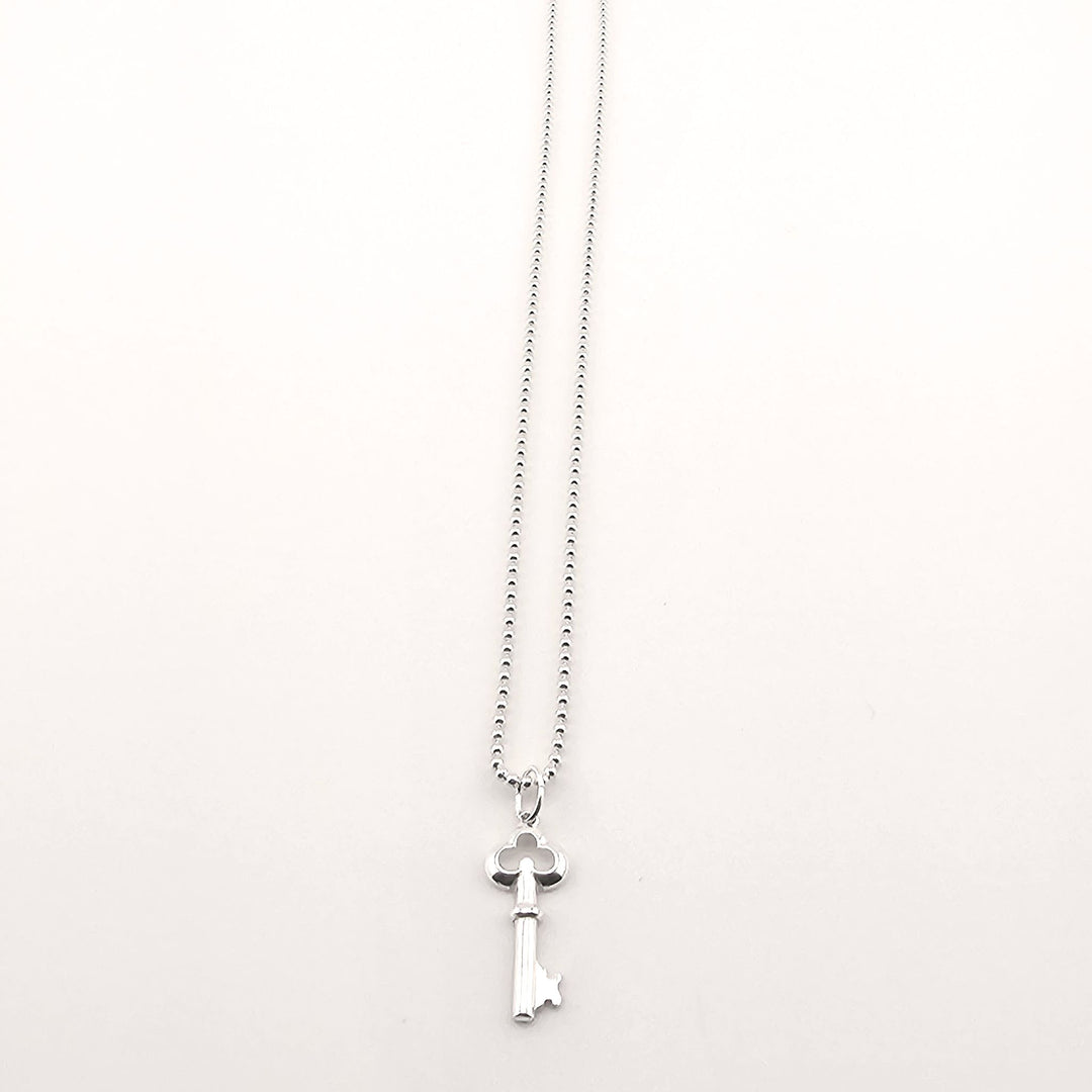 Sterling silver key necklace worn as symbolic unisex jewellery gift.