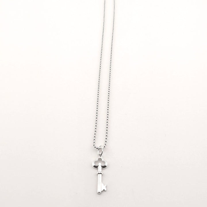 Sterling silver key necklace worn as symbolic unisex jewellery gift.