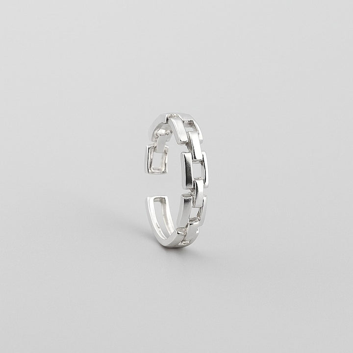Sterling silver chain link adjustable ring on grey background.
