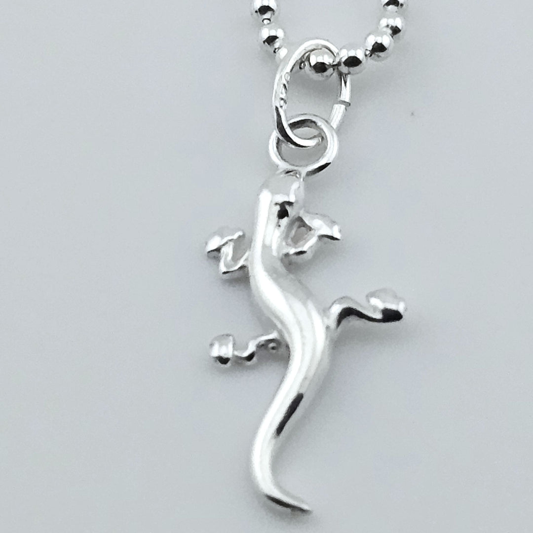 Close-up of sterling silver gecko necklace, animal-inspired jewellery.
