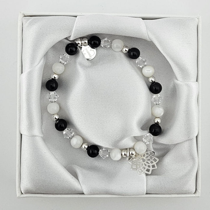 Spiritual beaded bracelet with lotus charm in silver.