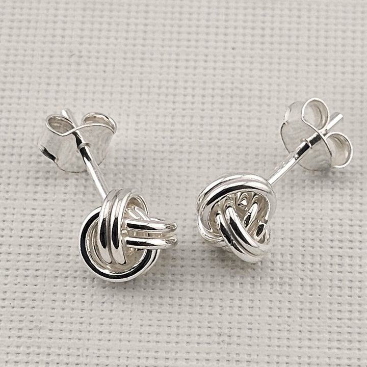 Timeless knot design silver earrings with butterfly backs.