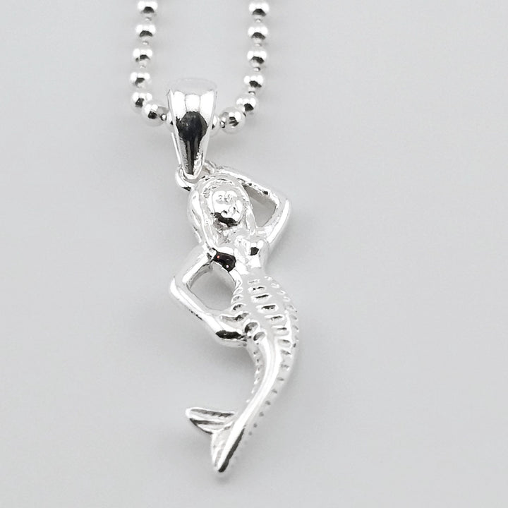 Sterling silver mermaid pendant necklace with ocean-inspired design.